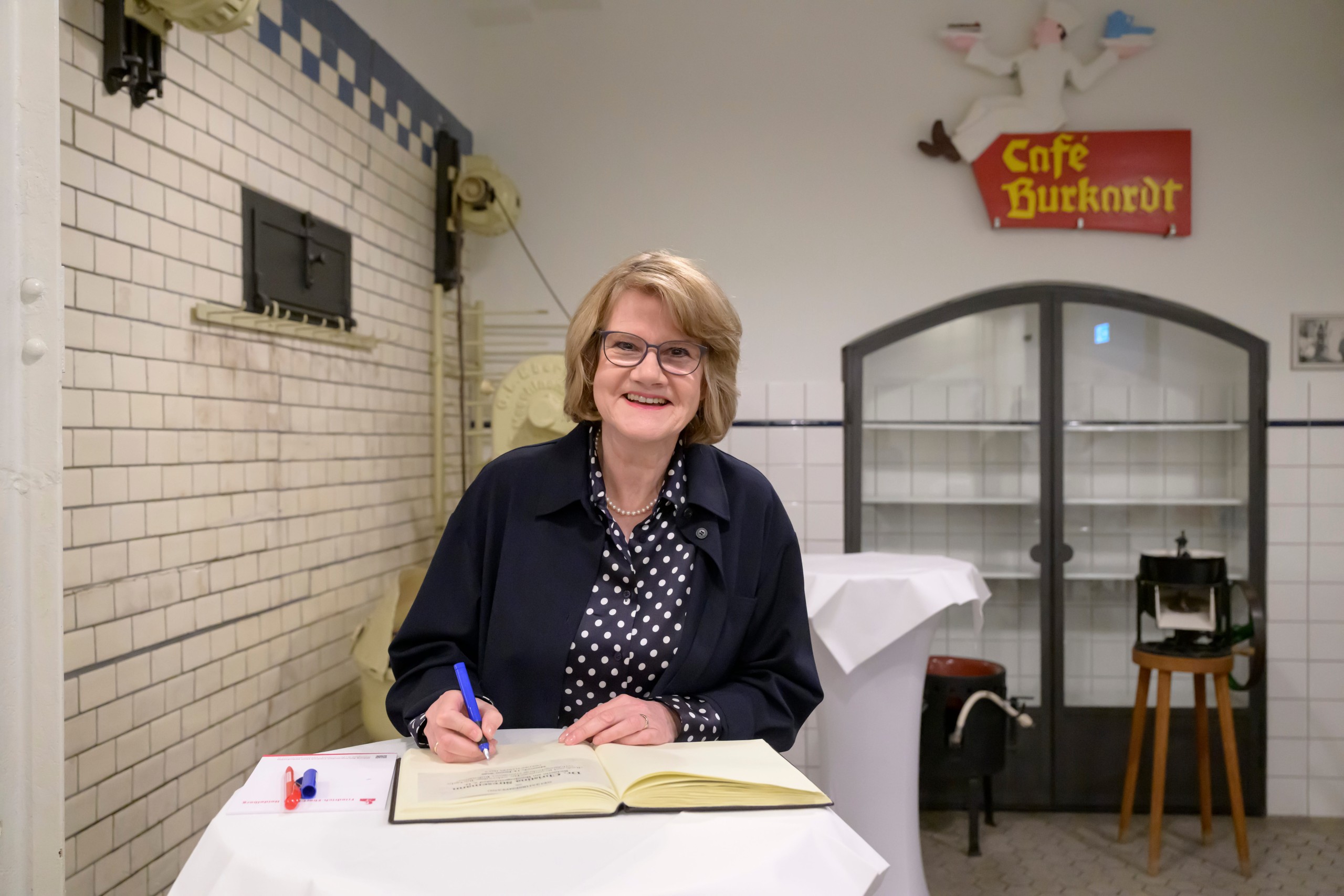 Dr. Christina Stresemann trägt sich ins Gästebuch ein.