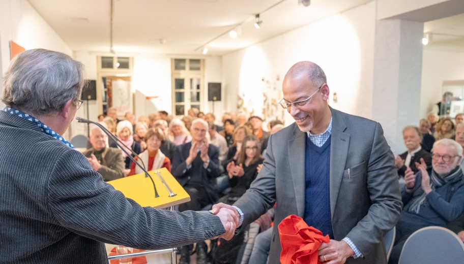 Prof. Dr. Bernd Braun überreicht Prof. Dr. Henry Keazor ein Geschenk.