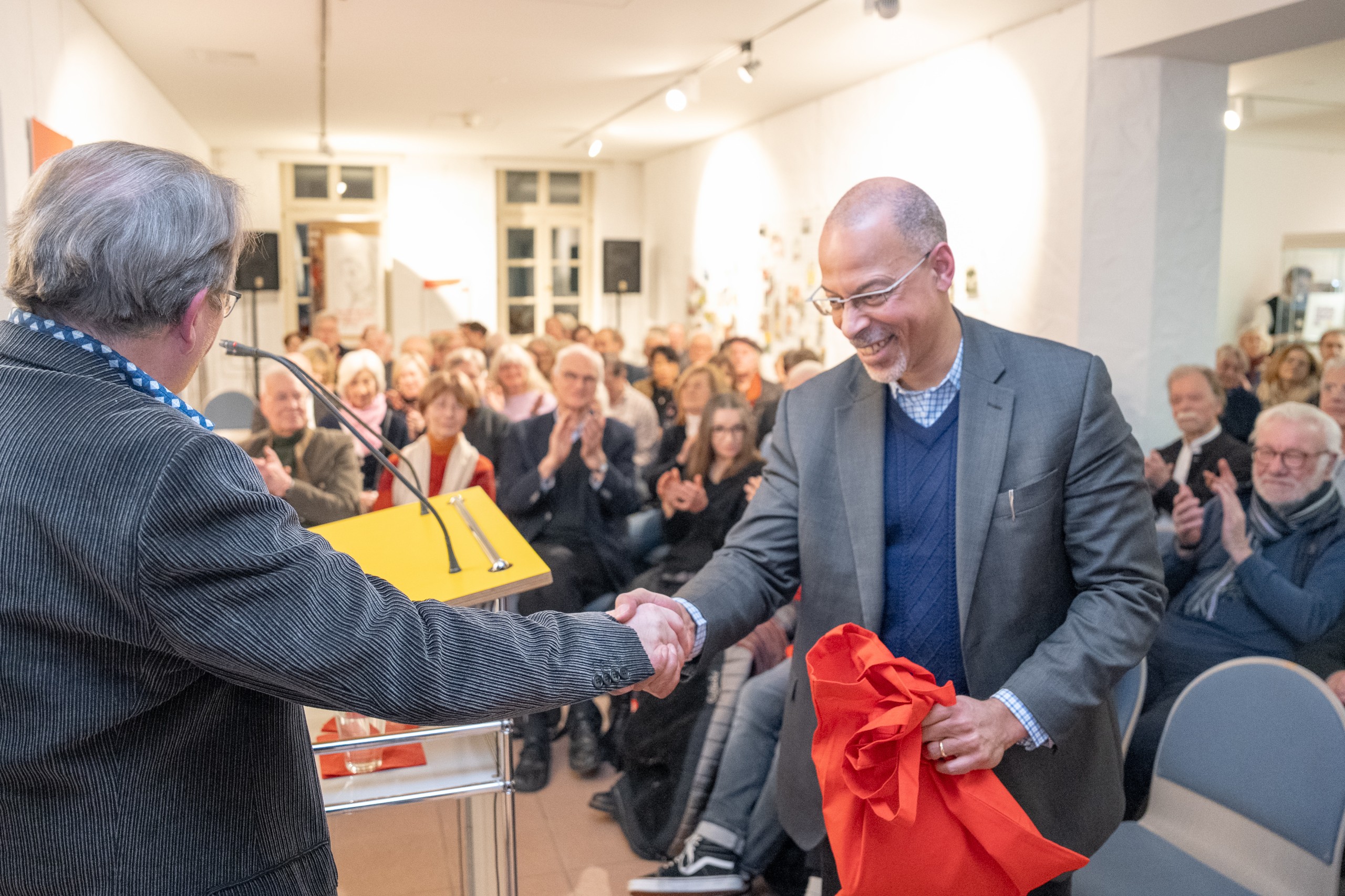 Prof. Dr. Bernd Braun überreicht Prof. Dr. Henry Keazor ein Geschenk.
