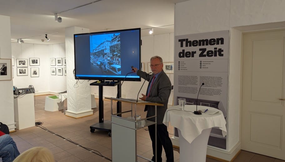 Marc Darchinger zeigt auf ein Foto.