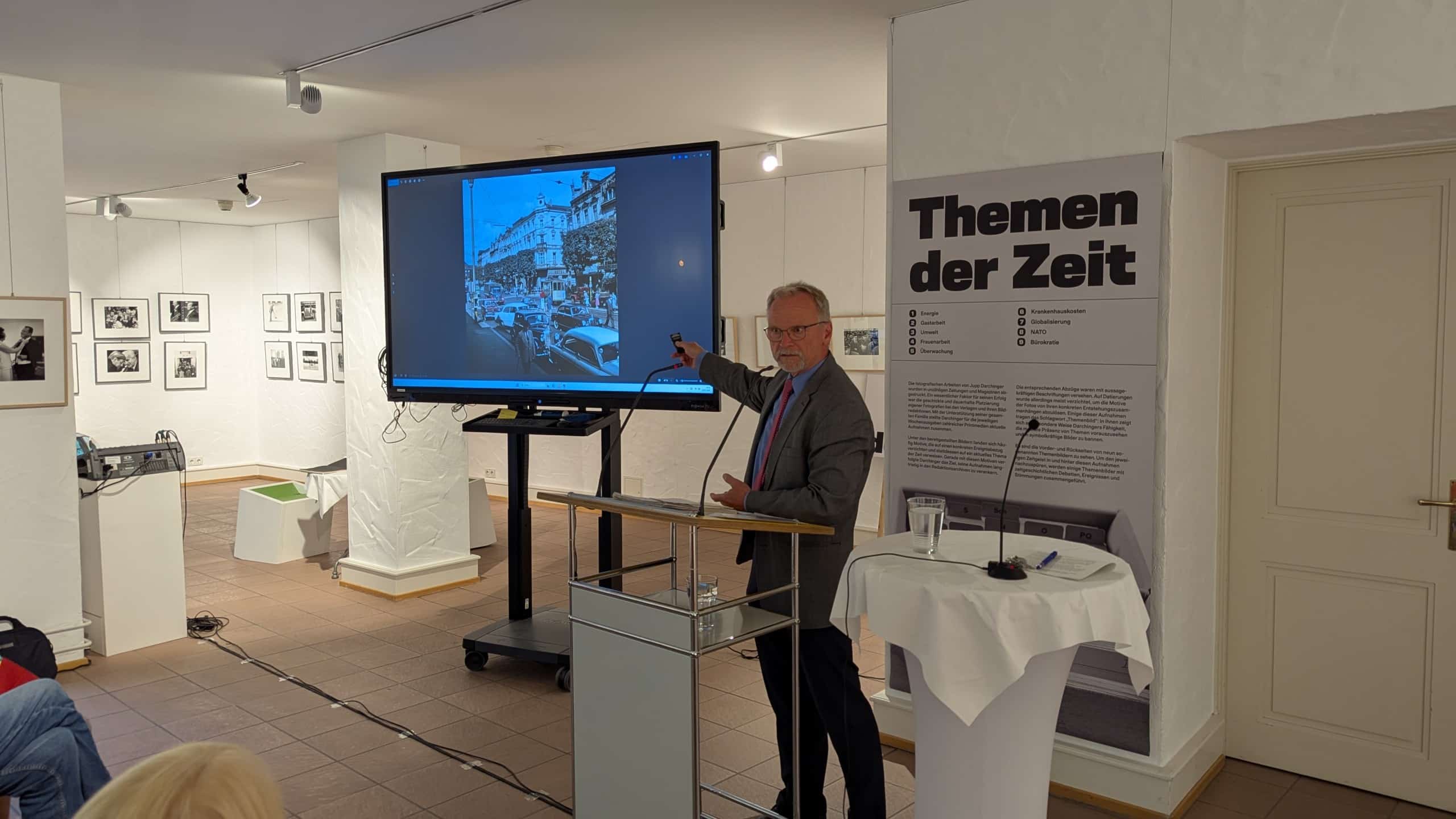 Marc Darchinger zeigt auf ein Foto.