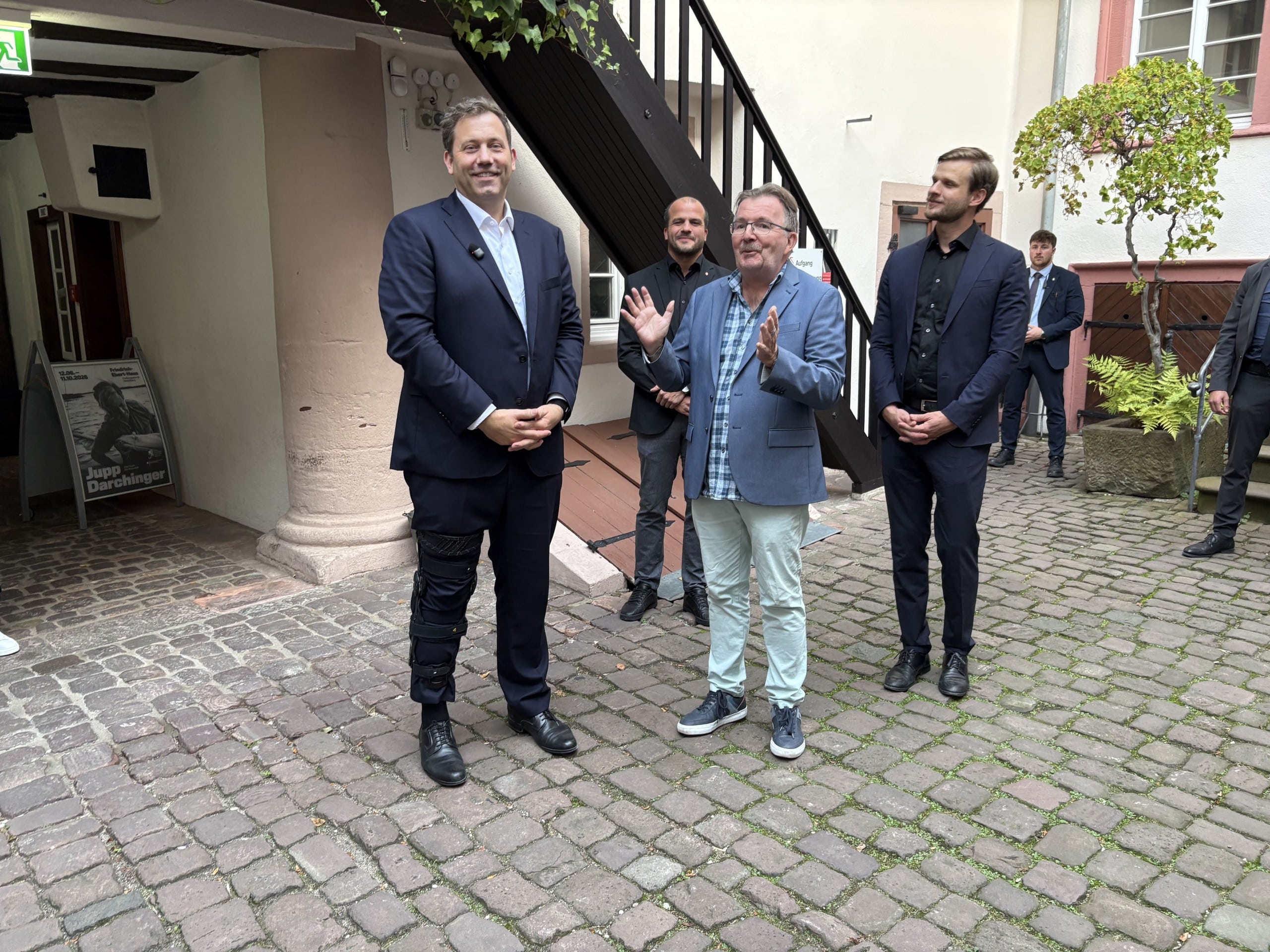 Geschäftsführer Prof. Dr. Bernd Braun begrüßt im Innenhof der Gedenkstätte (v. l. n. r.) Lars Klingbeil, Bundesvorsitzender der SPD, Vizekanzler und Bundesminister der Finanzen, Jan-Peter Röderer, Generalsekretär der SPD Baden-Württemberg, und Robin Mesarosch, Landesvorsitzender der SPD Baden-Württemberg.